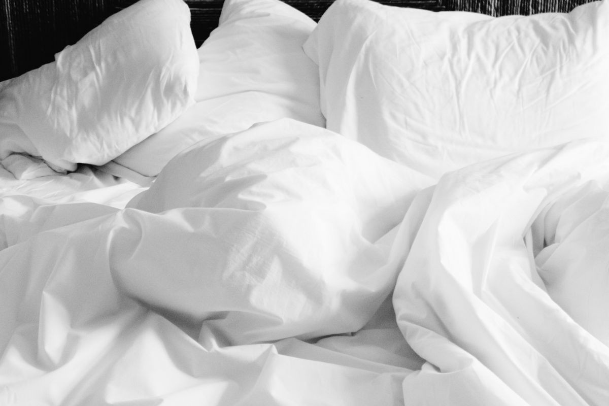 A plump white duvet insert with gentle quilted squares laid across a neatly made bed in daylight